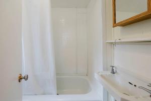 a white bathroom with a shower and a sink at 2-Bedroom Cottage #5 - Lodgepole Pine in Gravenhurst +2 photos