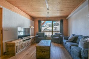 un salon avec un canapé et une télévision dans l'établissement Refuge Les Faitières F7, au Grand-Bornand