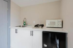 eine Küche mit Mikrowelle und Spüle in der Unterkunft Studio Cottage in Pine Lake #6 in Gravenhurst