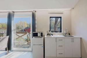 a kitchen with a white refrigerator and a microwave at Studio Cottage #8 - Jack Pine in Gravenhurst