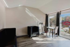 ein Wohnzimmer mit Fernseher und Tisch mit Stühlen in der Unterkunft Studio Cottage #8 - Jack Pine in Gravenhurst