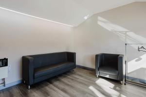 zwei schwarze Ledersessel in einem Raum mit weißen Wänden in der Unterkunft Studio Cottage #8 - Jack Pine in Gravenhurst + 8 Fotos