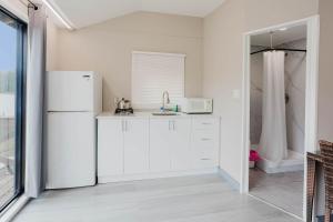 eine Küche mit weißen Schränken und einem weißen Kühlschrank in der Unterkunft Studio Cottage #9 - Virginia Pine in Gravenhurst + 3 Fotos