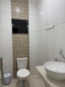 a bathroom with a white toilet and a sink at Apto Serras Gerais 2 in Dianópolis