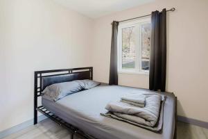 un lit dans une chambre avec une fenêtre dans l'établissement 2-Bedroom Cottage #10 - Pitch Pine, à Gravenhurst 13 autres photos