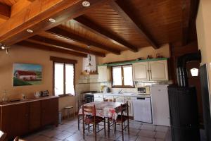a kitchen with white appliances and a table with chairs at La 2 CV Verte in Lesseux