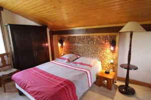 a bedroom with a bed and a wooden ceiling at La 2 CV Verte in Lesseux