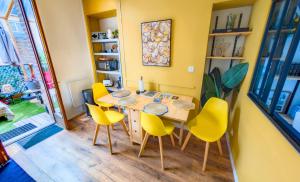 a dining room with a table and yellow chairs at Le Terrazza - 1P à 2P Terrasse - Henriville in Amiens +19 photos