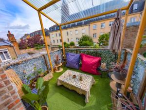 an outdoor patio with a table and colorful pillows at Le Terrazza - 1P à 2P Terrasse - Henriville in Amiens