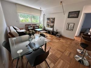 a living room with a glass table and chairs at Bicentenario Park Apartment in El Cerrillo