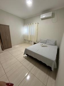 una camera da letto bianca con un letto e una finestra di Apto Serras Gerais 2 a Dianópolis