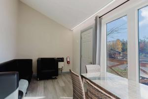 ein Wohnzimmer mit einem Glastisch und einem Fenster in der Unterkunft 2-Bedroom Cottage #11 - Red Pine in Gravenhurst