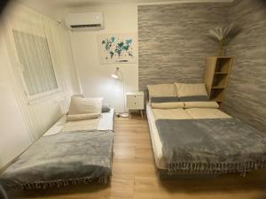 a room with two beds in a room with a window at Szeged Sunshine Apartman in Szeged +35 photos