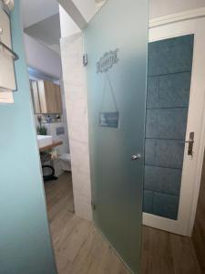 a bathroom with a glass door with a sign on the wall at Szeged Sunshine Apartman in Szeged +35 photos