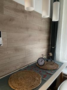 a table with a clock and a bicycle on it at Szeged Sunshine Apartman in Szeged
