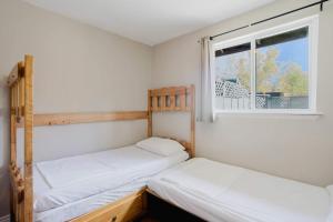 zwei Betten in einem Zimmer mit Fenster in der Unterkunft Pine Lake 3-Bedroom Cottage #12 - The Gallery in Gravenhurst