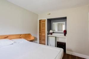 ein Schlafzimmer mit einem Bett, einem Waschbecken und einem Spiegel in der Unterkunft Pine Lake 3-Bedroom Cottage #12 - The Gallery in Gravenhurst