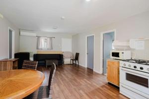 eine Küche und ein Wohnzimmer mit Tisch und Herd in der Unterkunft Pine Lake 3-Bedroom Cottage #12 - The Gallery in Gravenhurst + 12 Fotos