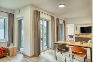 a living room with a table and two chairs at Sattler Living Apartments in Ebbs +24 photos