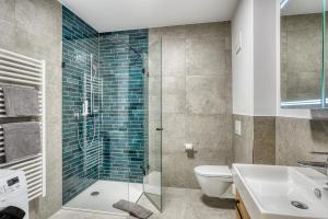 a bathroom with a shower and a toilet and a sink at Sattler Living Apartments in Ebbs