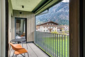 a balcony with a table and chairs and a view of a mountain at Sattler Living Apartments in Ebbs