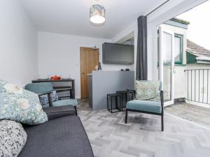 a living room with a couch and chairs and a kitchen at Claife Flights in Bowness-on-Windermere
