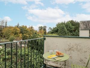 a table with a plate of food on a balcony at Claife Flights in Bowness-on-Windermere