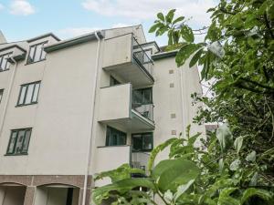 an apartment building with balconies and trees at Claife Flights in Bowness-on-Windermere