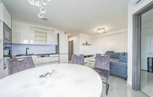 een keuken en woonkamer met een witte tafel en stoelen bij Move in Appartment in Mosonmagyaróvár