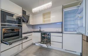 een keuken met witte kasten en een open koelkast bij Move in Appartment in Mosonmagyaróvár