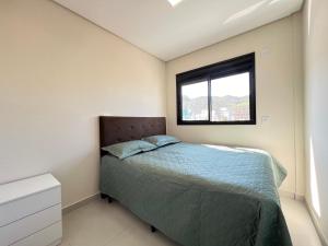 un dormitorio con una cama y una ventana en Sea view apartment with 3 bedrooms and garage, en Governador Celso Ramos