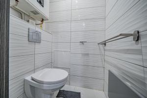 een witte badkamer met toilet en douche bij Move in Appartment in Mosonmagyaróvár