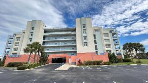 a large building with a parking lot in front of it at Seashell Escape in New Smyrna Beach