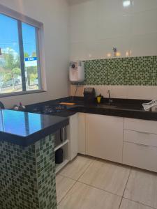 una cucina con piano di lavoro nero e lavandino di Apto Serras Gerais 2 a Dianópolis