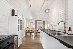 a white kitchen with a sink and a table at SJ314-Haderslev-Kelstrup-Norreskov-42 in Kelstrup Strand
