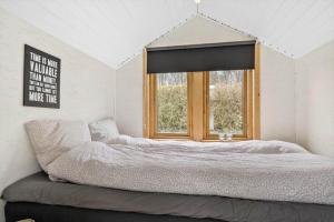 a bedroom with a large bed with a window at SJ314-Haderslev-Kelstrup-Norreskov-42 in Kelstrup Strand