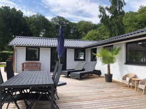 a patio with a table and chairs and an umbrella at SJ314-Haderslev-Kelstrup-Norreskov-42 in Kelstrup Strand +32 photos