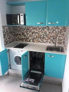 ル・ゴジエにあるStudio accueillant avec vue mer à Le Gosierのキッチン(青いキャビネット、洗濯機付)