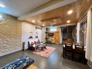 a living room with a couch and a table at Rustic Roots Home Stay in Nagar