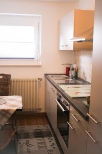 a kitchen with a stove and a sink and a window at Ferienwohnung Talblick in Meßstetten
