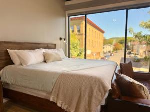 a bedroom with a bed and a large window at The Benjamin Hotel in Watkins Glen