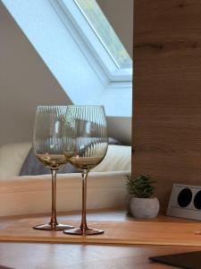 two wine glasses sitting on a table in front of a window at Idyllisches Wohnen im Schloss in Bruchhausen-Vilsen
