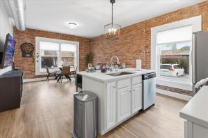 eine Küche mit Spüle und Ziegelwand in der Unterkunft Mass Ave Retreat with Big Patio and Free Parking in Indianapolis