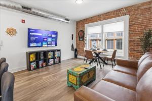 ein Wohnzimmer mit Sofa und Tisch in der Unterkunft Mass Ave Retreat with Big Patio and Free Parking in Indianapolis