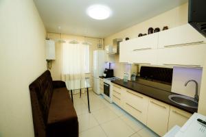 une cuisine avec des armoires blanches et un comptoir noir dans l'établissement Розкішна двокімнатна квартира на Розсошенцях у м Полтава Документи для відрядження, à Shcherbani