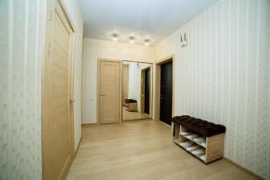 un couloir avec des murs blancs et un parquet, et un couloir avec un tabouret dans l'établissement Розкішна двокімнатна квартира на Розсошенцях у м Полтава Документи для відрядження, à Shcherbani