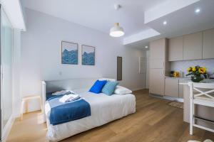 ein weißes Schlafzimmer mit einem Bett und einem Schreibtisch in der Unterkunft Beach Apartment by Portugal Portfolio in Paço de Arcos