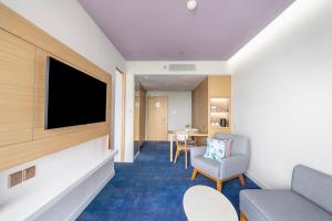 a hotel room with a tv and a couch and a table at OZO Medini Malaysia in Nusajaya