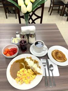 uma mesa com pratos de comida sobre uma mesa em Hotel ALO! Express em Torreón
