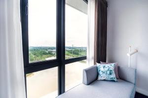 a room with a chair and a large window at OZO Medini Malaysia in Nusajaya